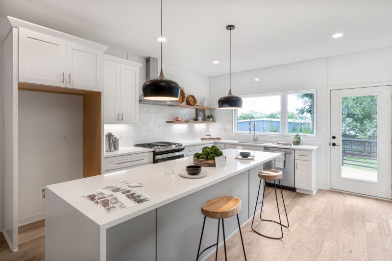 Home 10 Bright modern kitchen with white cabinetry wooden stools and 1792515725